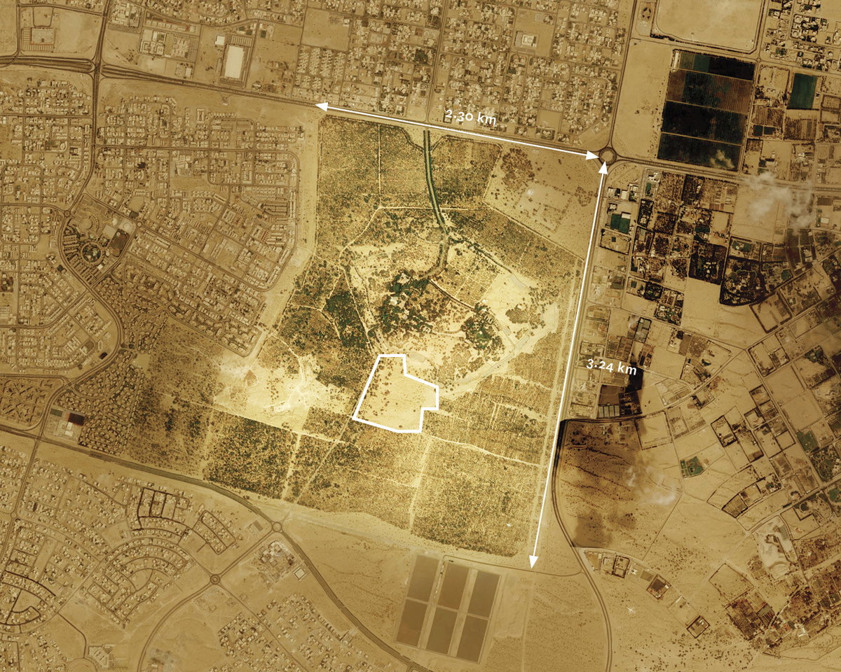 Satellitenansicht eines Wüstenstadtgebiets mit einem weiß markierten Rechteck und Distanzangaben.