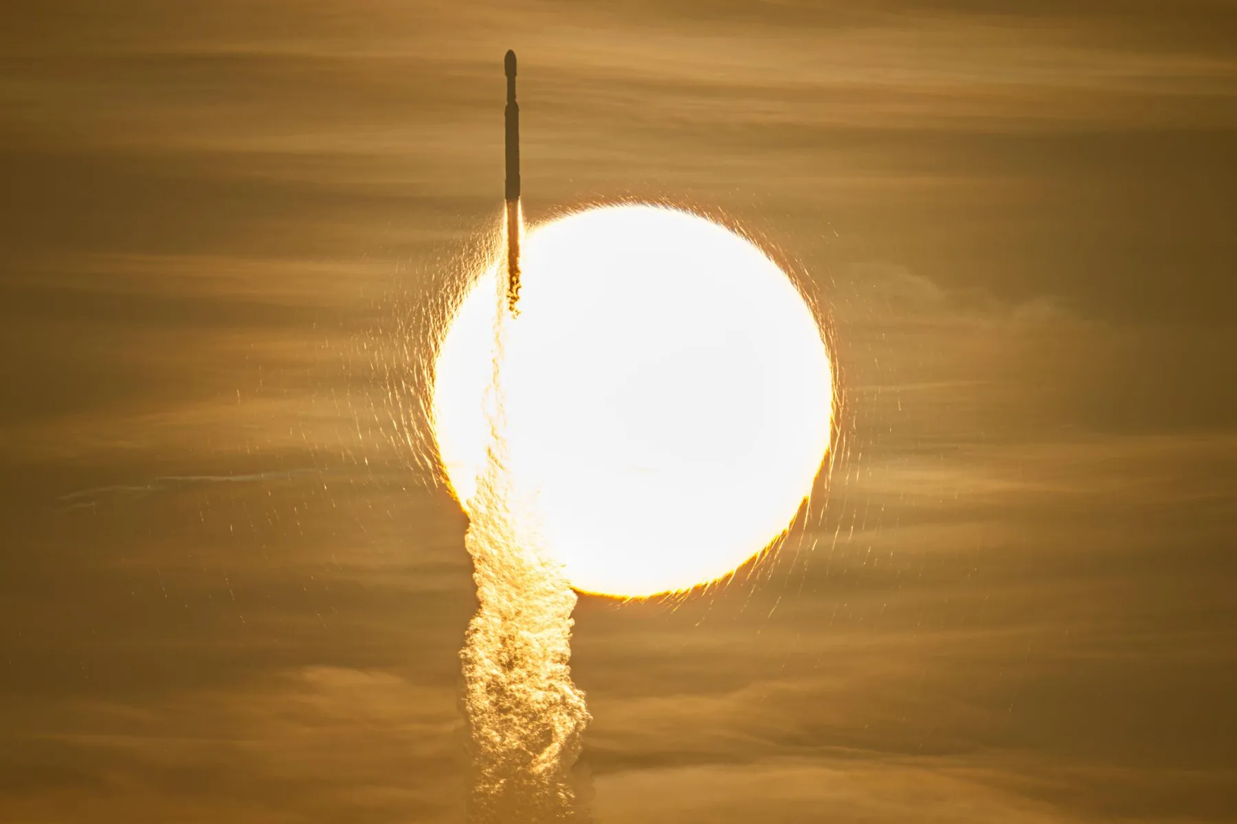Die Falcon-Heavy-Rakete mit Roman beim Start am 30. August 2026, von der Erde aus vor der Sonne fotografiert.